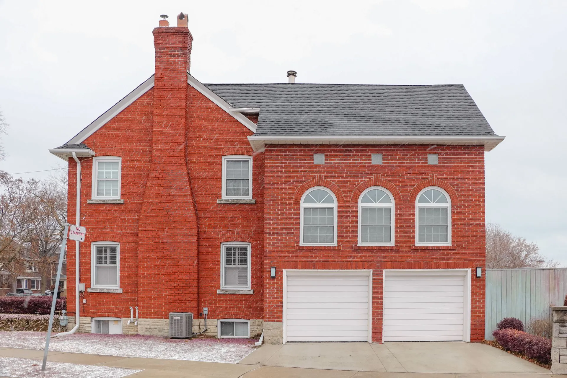 Red brick building with two white garage doors