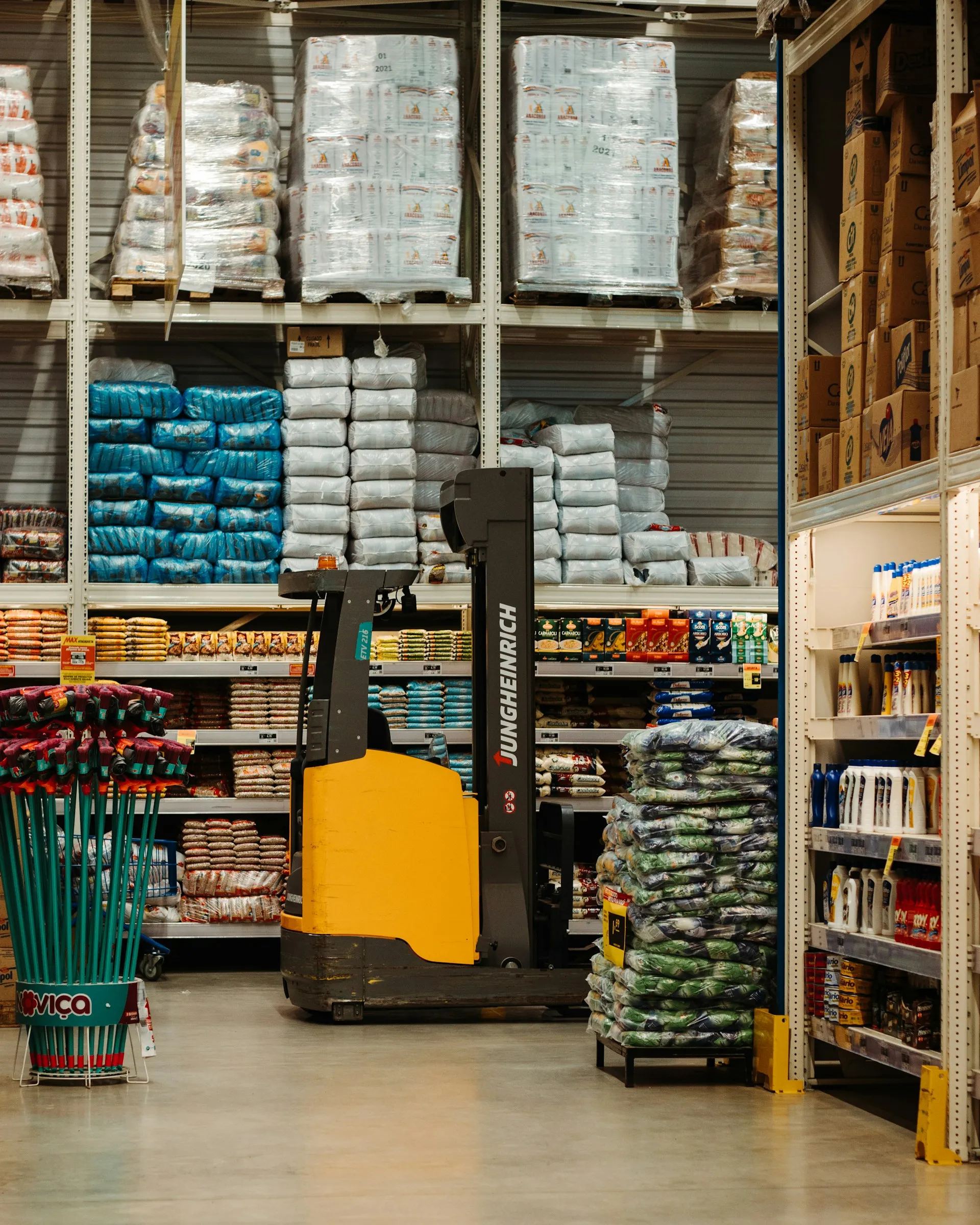 Forklift in a stocked warehouse aisle