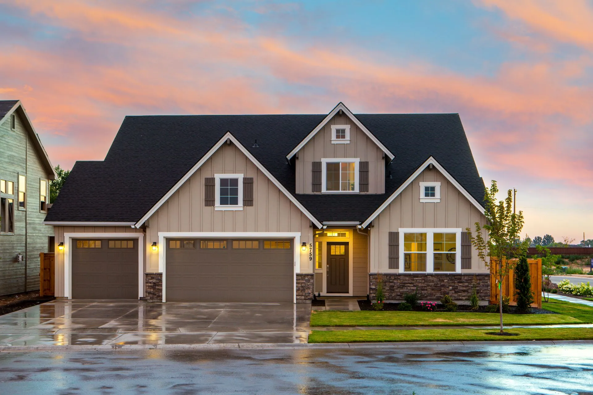 Craftsman home with a three-car garage at sunset